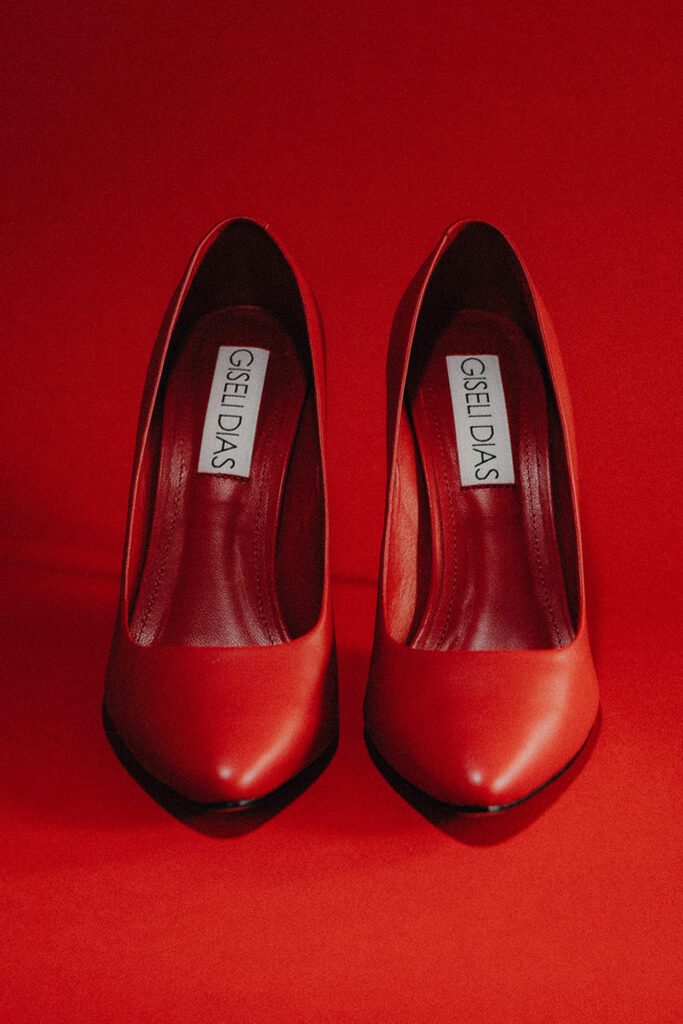Scarpin de luxo Vic Red da Giseli Dias em couro vermelho, bico fino e salto agulha de aço preto de 100 mm, feito à mão no Brasil. Sapatos de Luxo Brasileiros