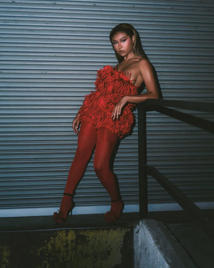 Sierra Capri usando sandálias Audrey Black da Giseli Dias, com flores vermelhas esculturais, em editorial da Numéro Netherlands